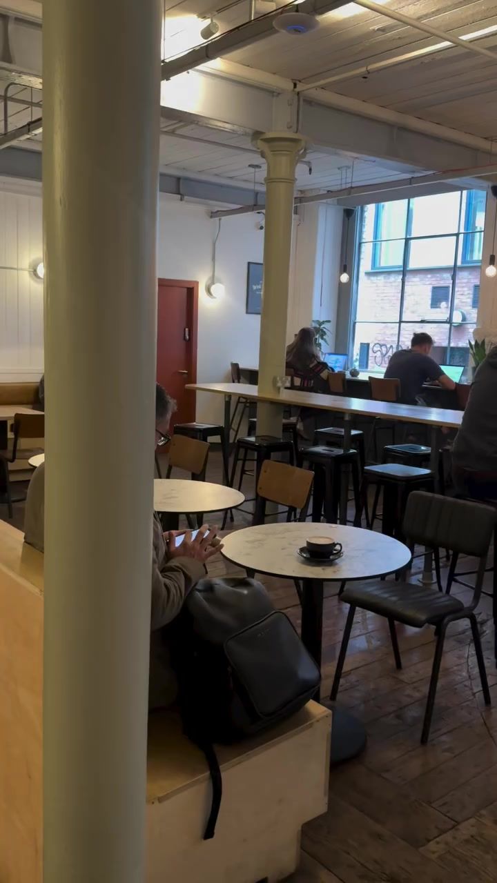 Laptops open on the long tables by the tall windows