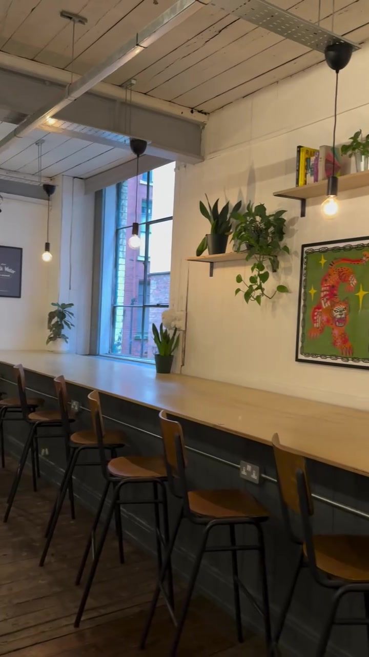 The long window bar with plants and stools, red brick outside